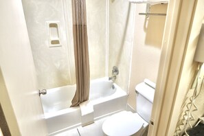 A bathroom with a bathtub, toilet, and a shower curtain.