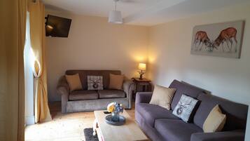 A living room with a sofa, a coffee table, a lamp, and a painting on the wall.