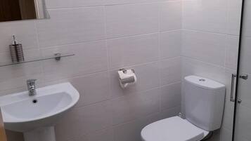 Ein Badezimmer mit Waschbecken, Toilette und Spiegel über dem Waschbecken.