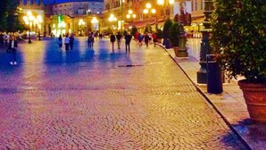 Una plaza adoquinada con edificios históricos y farolas.