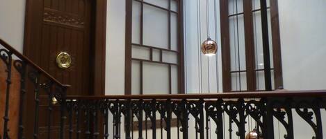 A staircase with ornate black railings and a wooden door marked "EXIT".