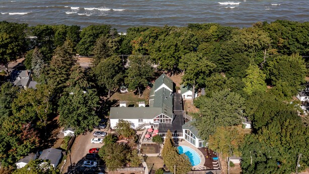 Une vue aérienne d’une maison avec une piscine, entourée d’une végétation dense et offrant une vue sur l’océan.