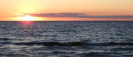 A sunset over the ocean with waves.