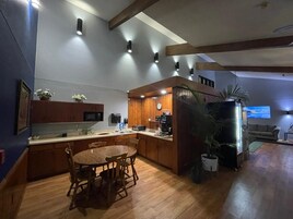 Una cocina moderna con armarios de madera, una mesa de comedor y una cafetera.
