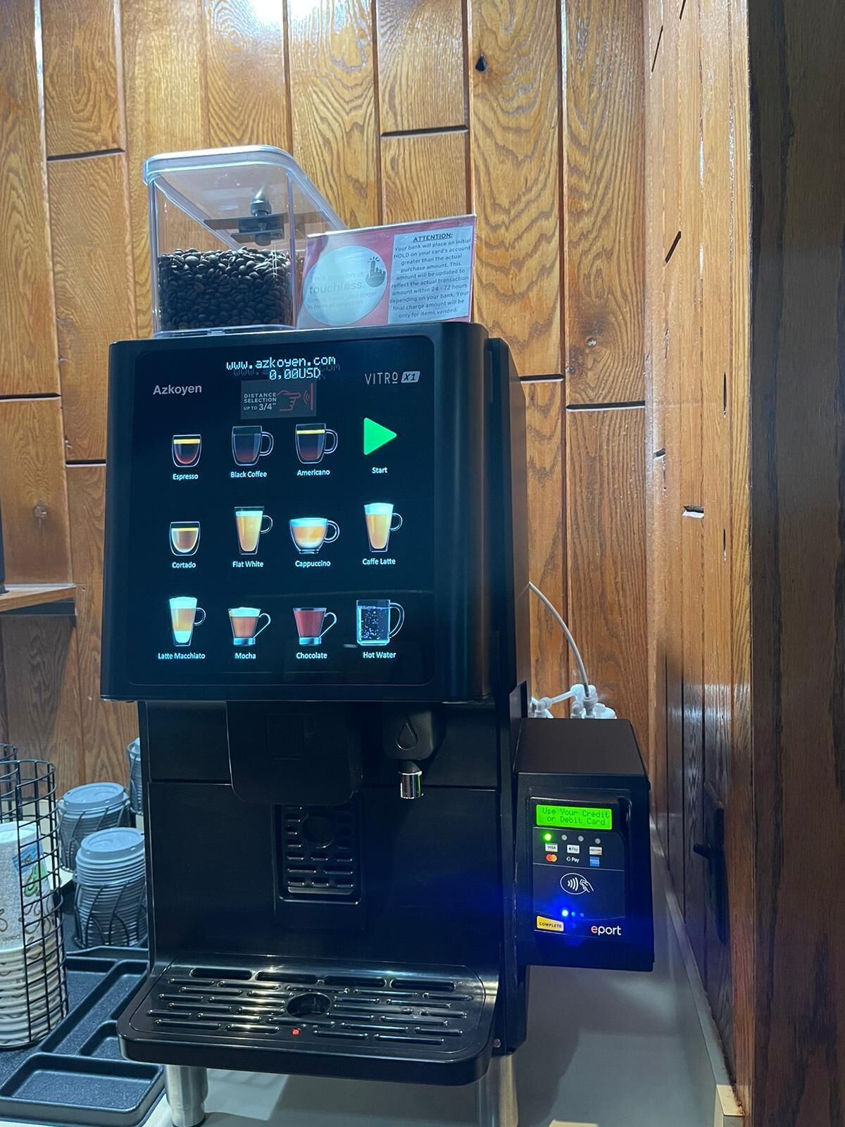 A coffee machine with a digital display menu for various coffee types.