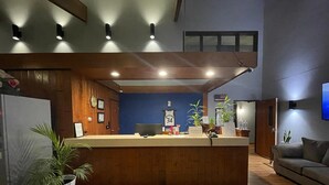 A reception area with a wooden reception desk, a blue wall, and a welcome mat.