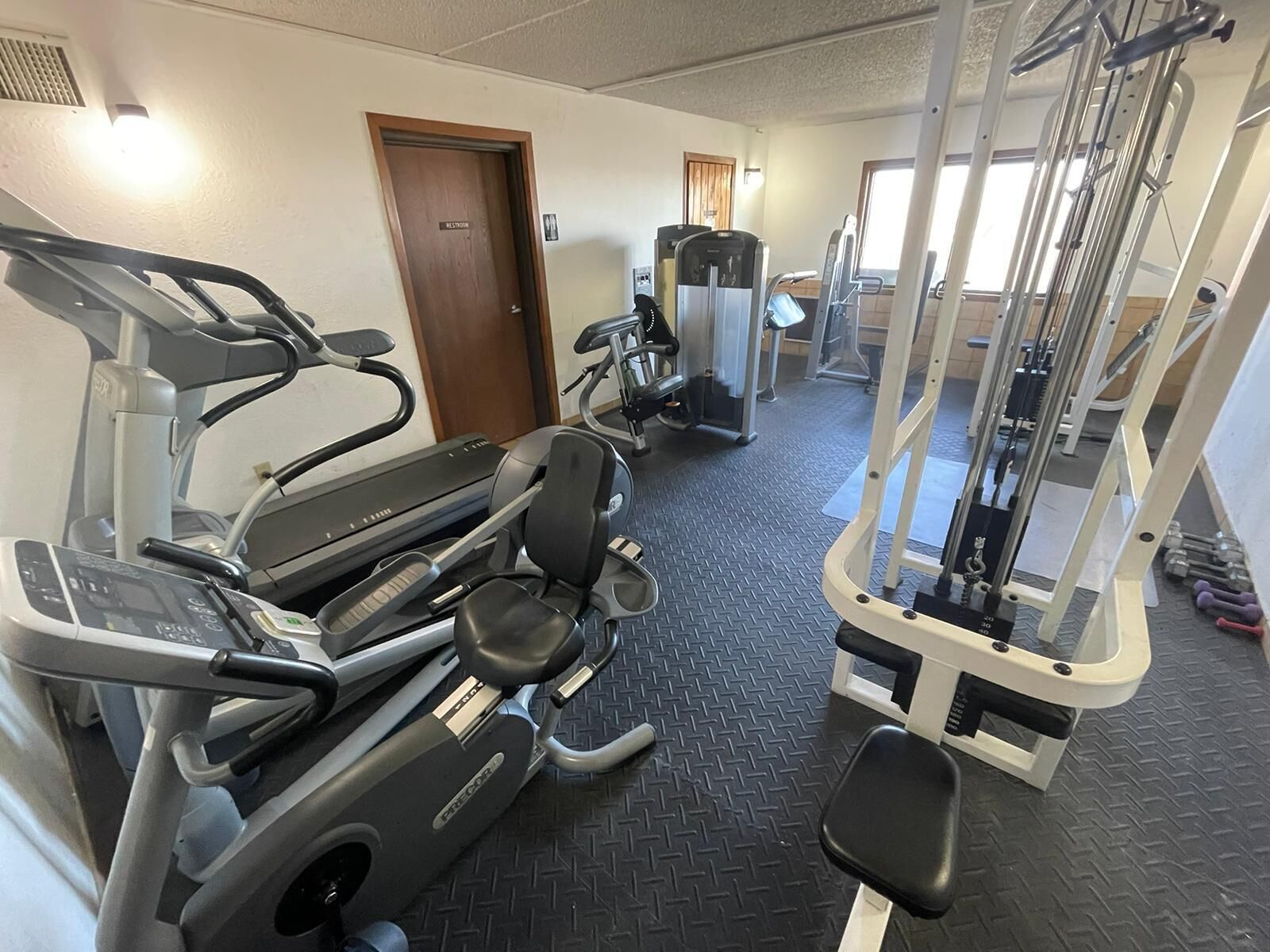 A gym with treadmills, elliptical machines, and weight machines.