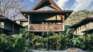 A modern building with a sloped roof and a wooden balcony. - Lua Villas (Cóbano)