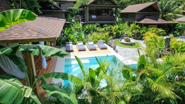 A resort with a swimming pool surrounded by lush greenery and multiple bungalow-style buildings. - Lua Villas (Cóbano)