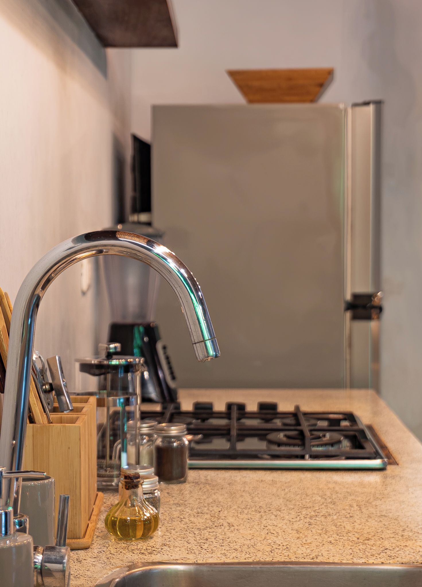 A kitchen with a stainless steel sink, a gas stove, and a wooden utensil holder.