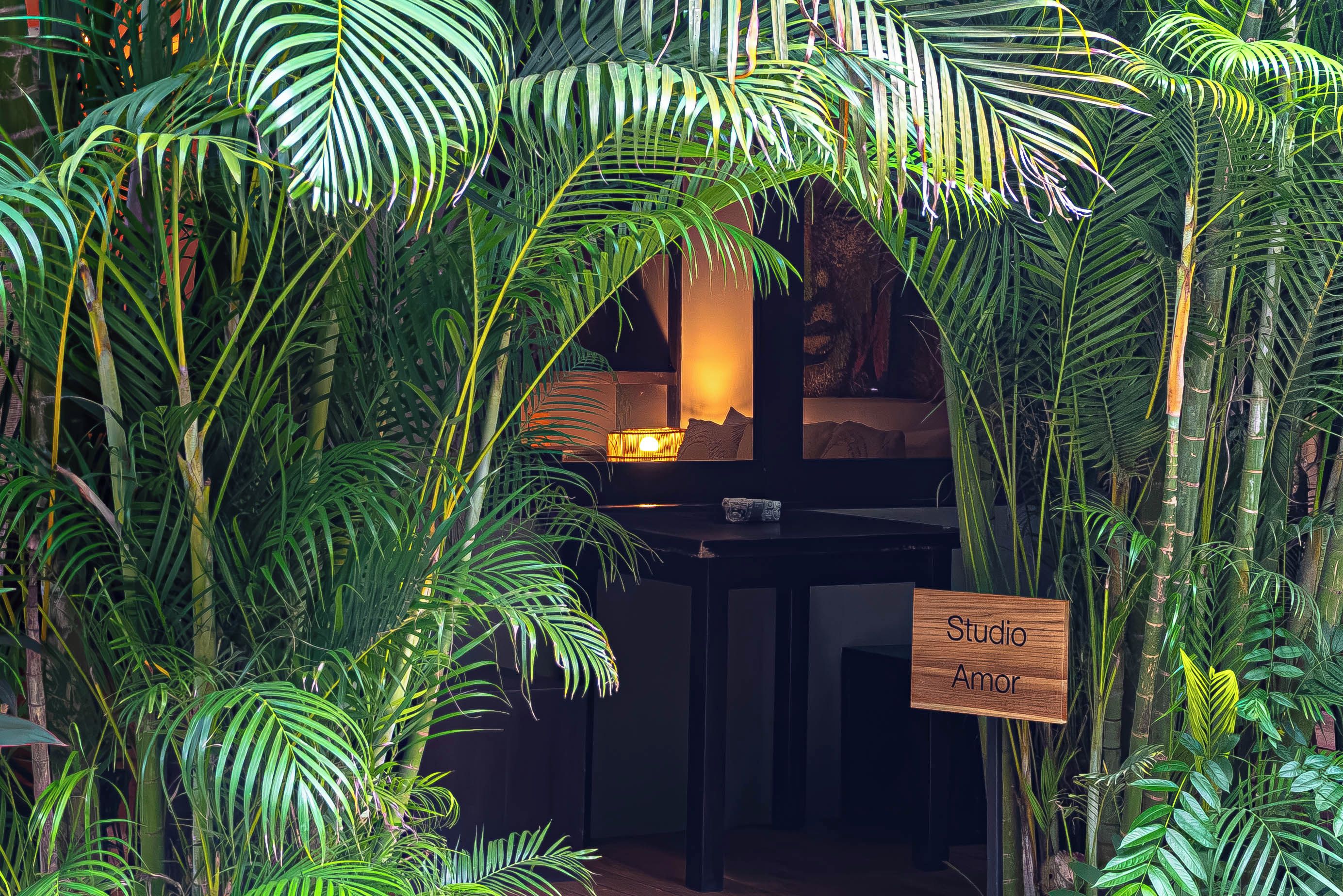 A room with a dark wooden desk, a lamp, and a sign reading 'Studio Amor'.