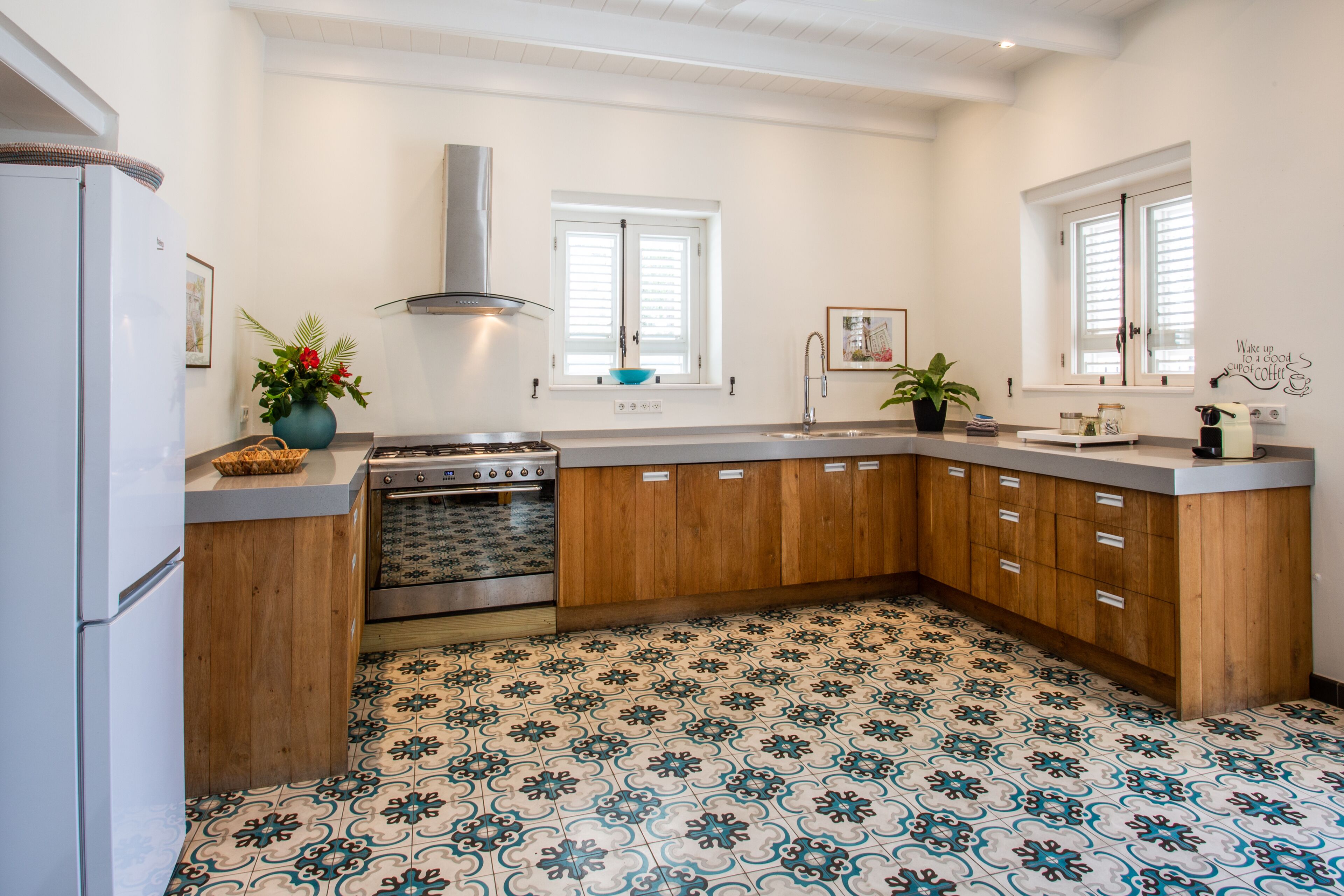 A kitchen with a stove, sink, and wooden cabinets.