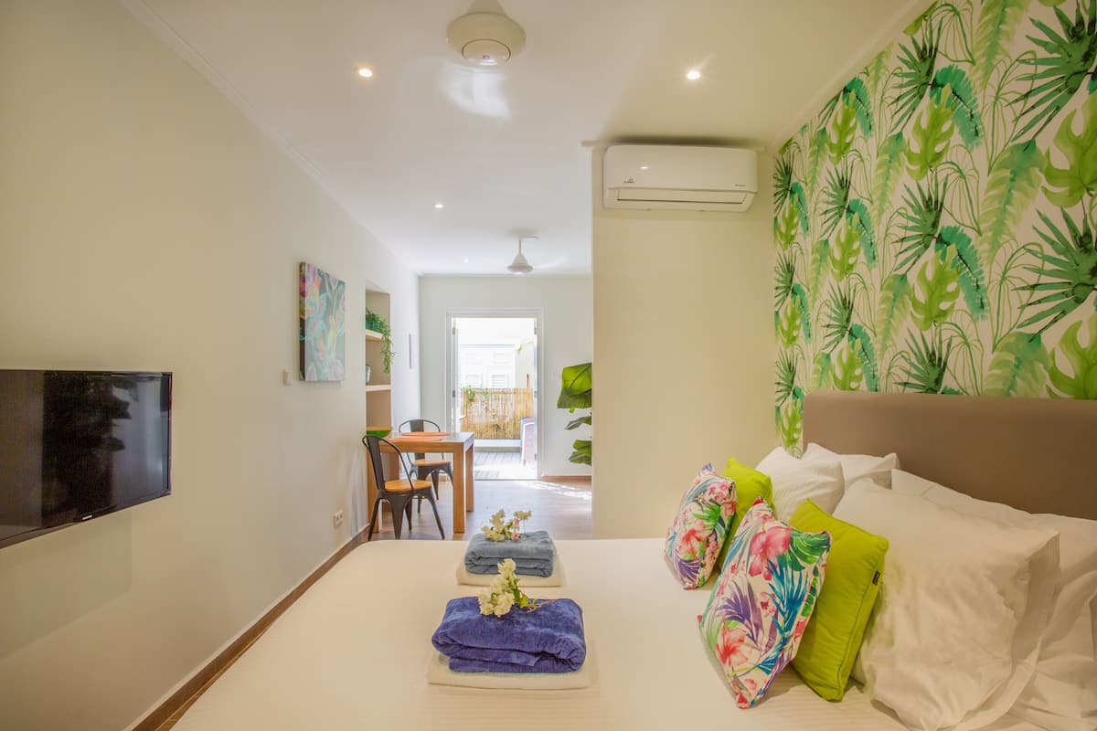 Una habitación de hotel con una cama, televisor, escritorio y una silla.