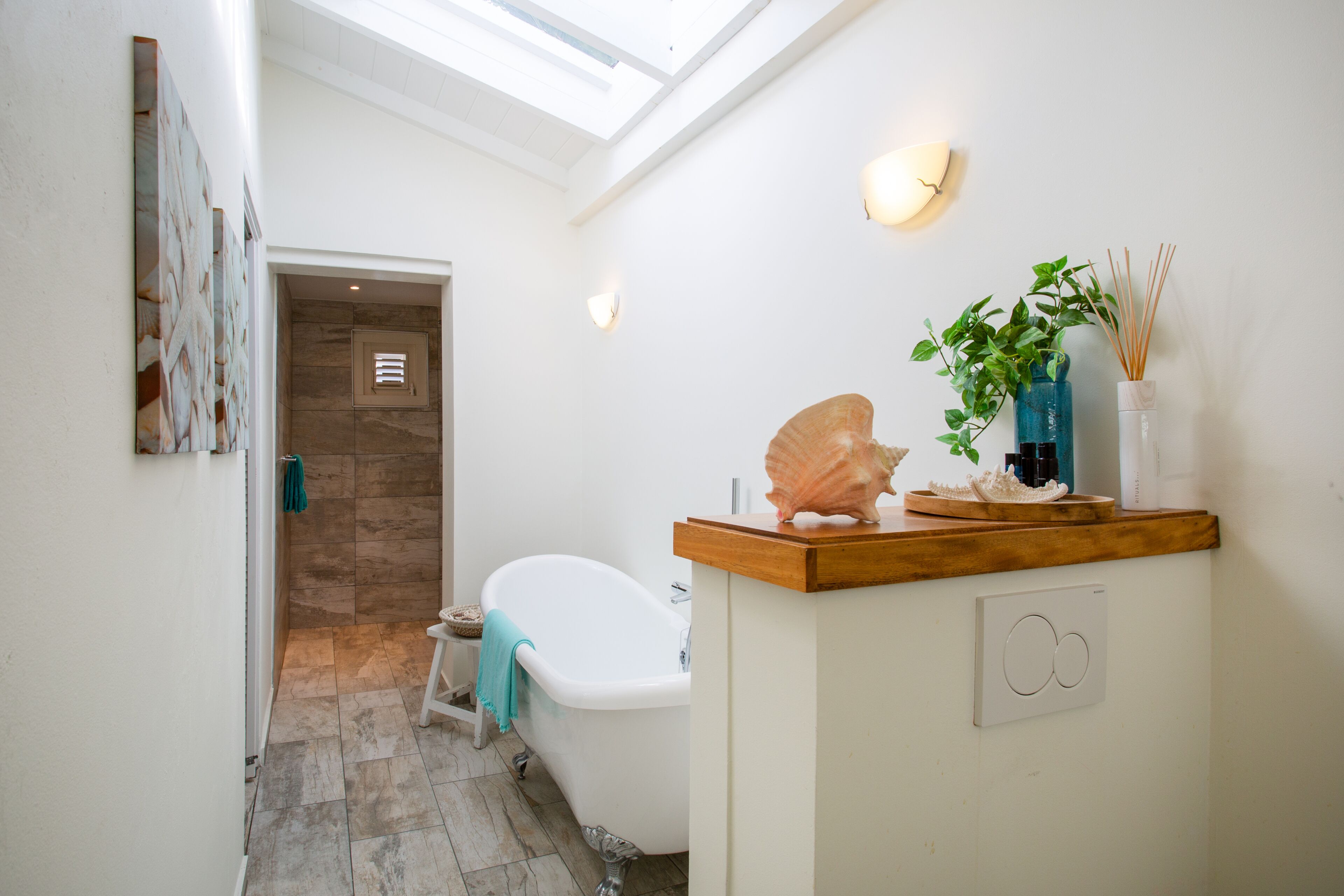 A modern bathroom with a freestanding bathtub, a wooden vanity, and a skylight.