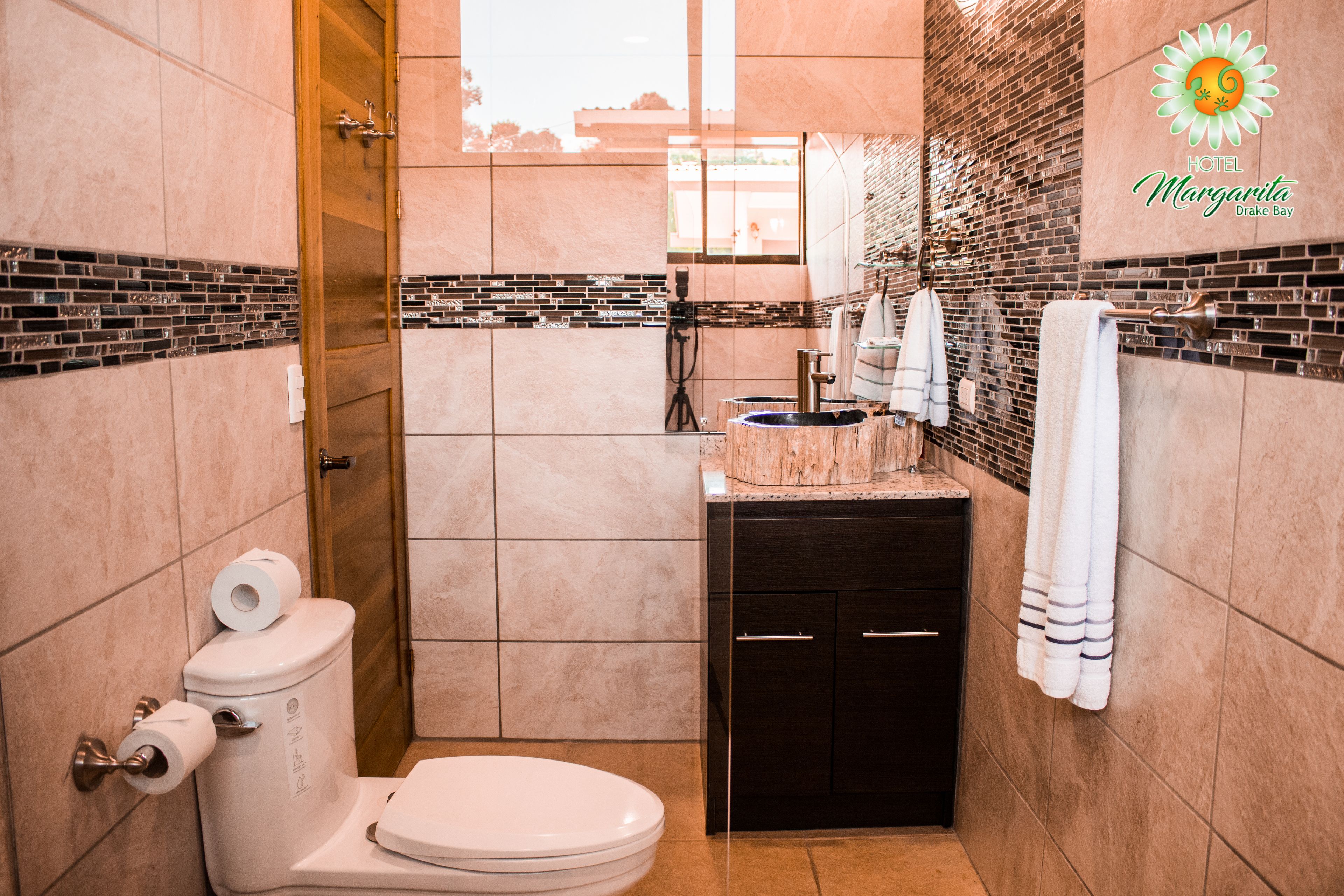 Une petite salle de bain comprenant des toilettes, un lavabo et un porte-serviettes.