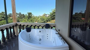 A hot tub on a balcony with a clear view of the surrounding landscape. - Hotel Margarita (Drake Bay)