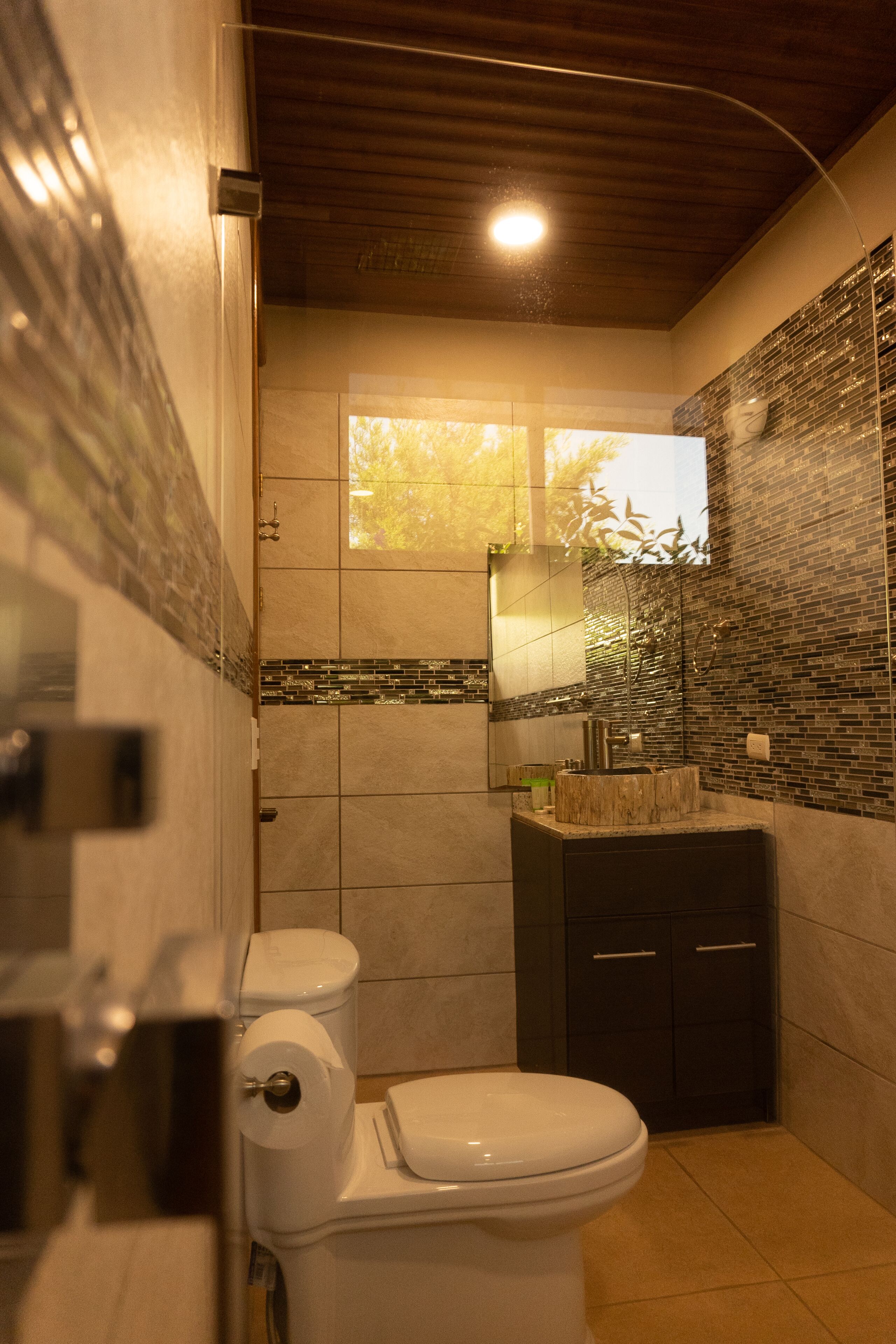Une salle de bain moderne équipée de toilettes, d’un lavabo et d’un espace douche.