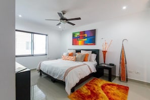 A modern bedroom with a bed, a ceiling fan, a colorful abstract painting, and a tall vase. - Awah by CocoBR (Playa del Carmen)