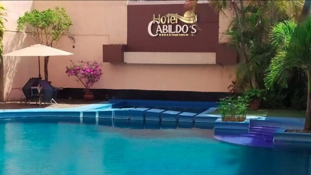 Zona de piscina de un hotel, con un letrero que indica 'Hotel Cabildo'.