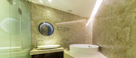 A modern bathroom with a glass shower enclosure, a freestanding bathtub, and a vanity with a sink.