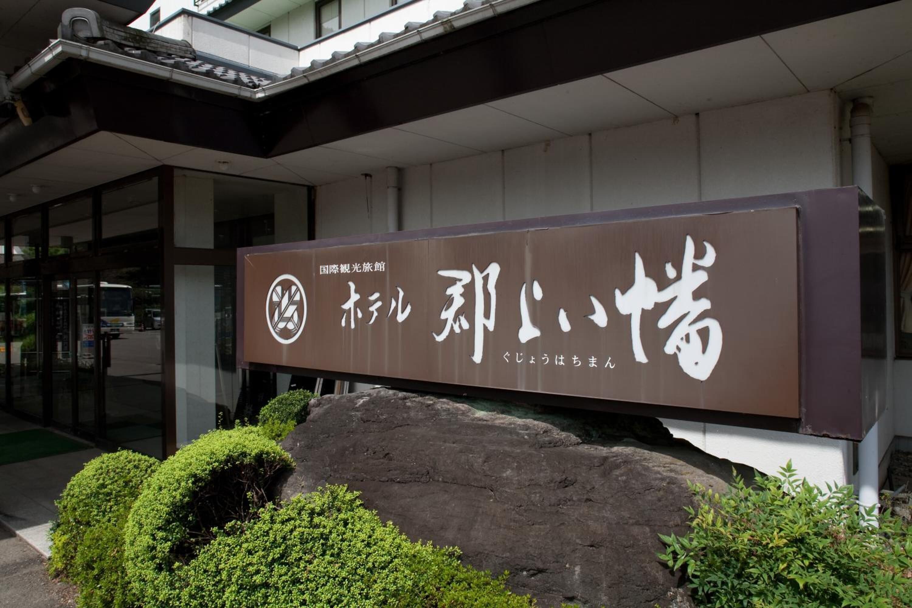 A sign with Japanese characters and a logo, indicating a travel-related establishment.