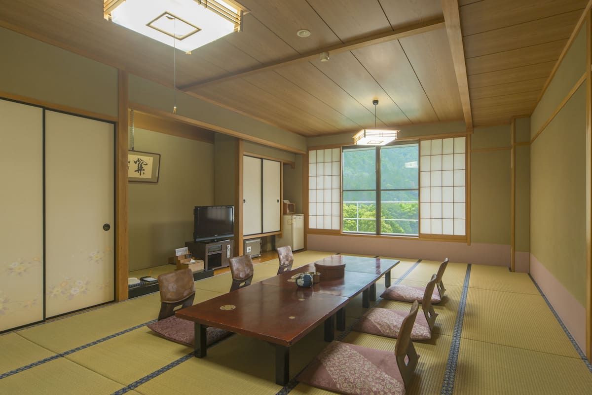 A traditional Japanese room with tatami flooring, a low table, and sliding doors.