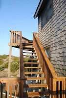 Una escalera de madera que conduce a un edificio con revestimiento de tejas.