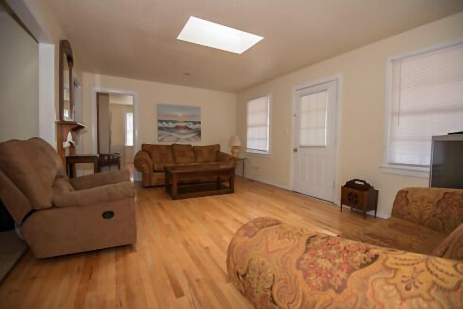 A spacious living room with a sofa set, a coffee table, and a television.