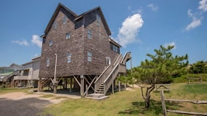A multi-story building with a stone facade and a wooden staircase leading to the entrance. - Avon Cottages (Avon)