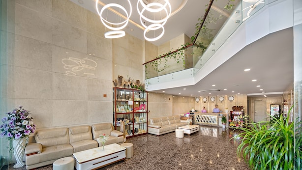 A spacious lobby with a high ceiling, a reception desk, seating area, and a staircase. - Lavender Riverside Hotel (Da Nang)