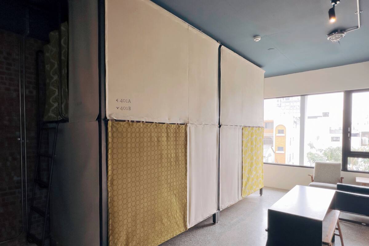 A modern office space with partitioned work areas, a large window offering a view of the city, and a simple, functional design.