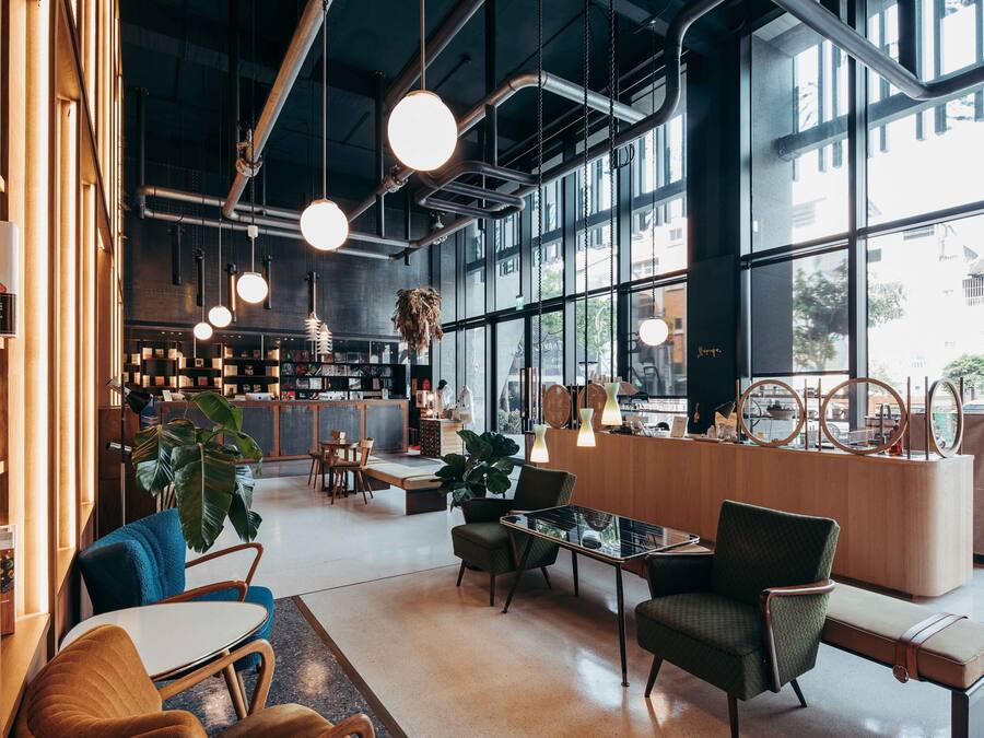 Ein modernes Interieur mit Sitzgelegenheiten, einer Theke und großen Fenstern.