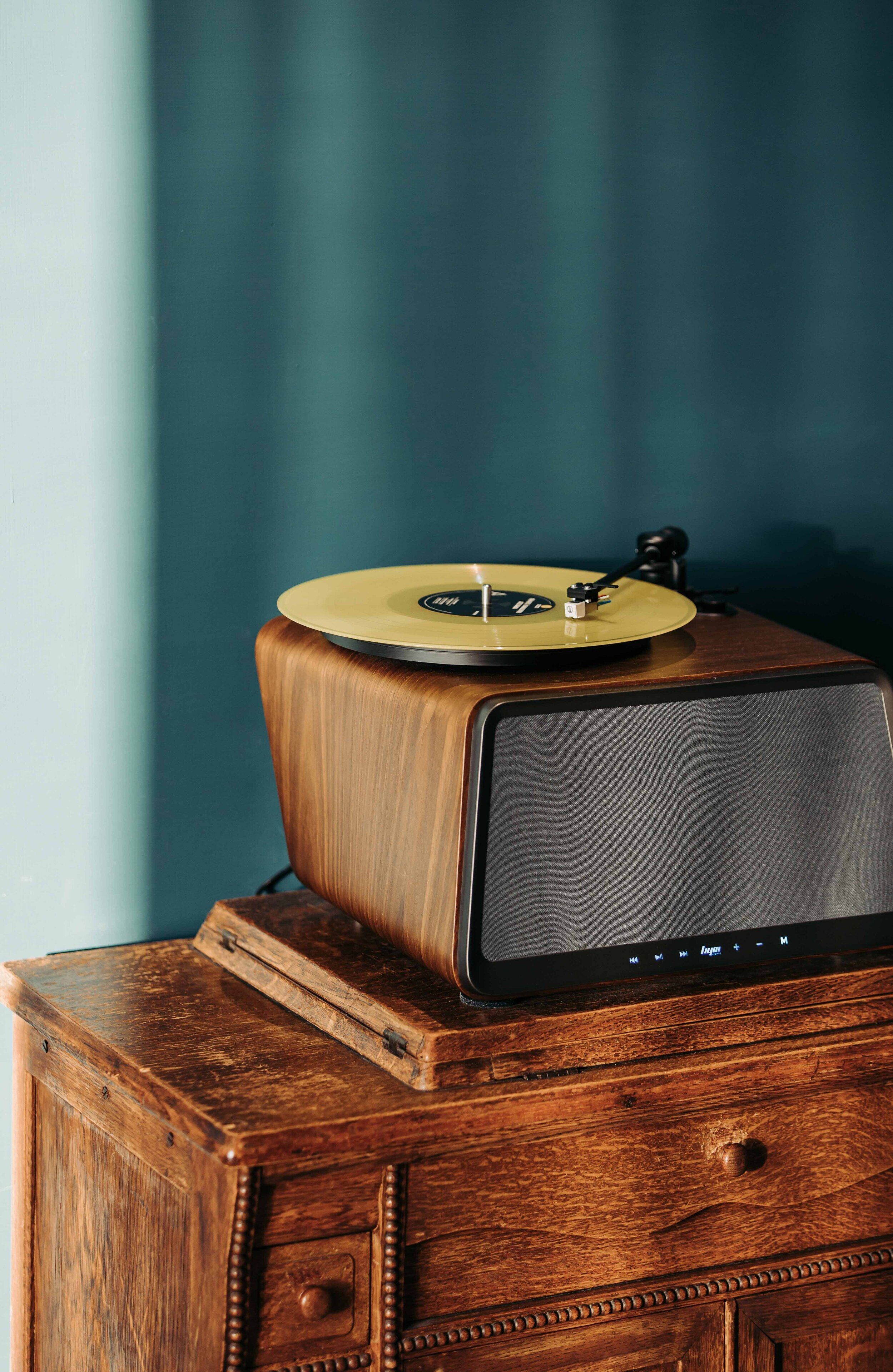 A wooden cabinet with a vintage radio and a record player on top.