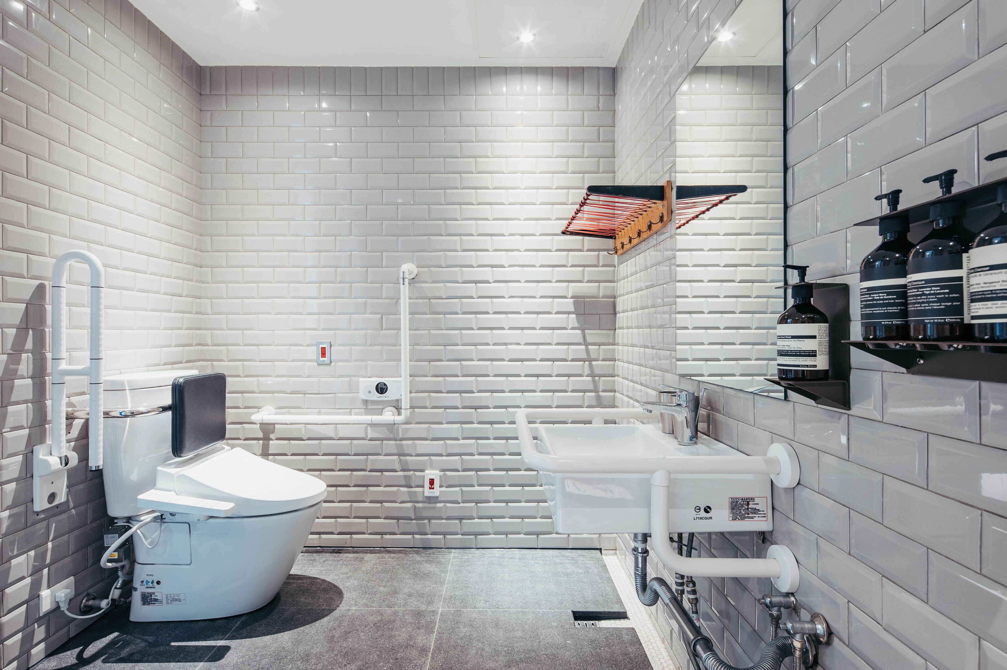 A modern bathroom with a white toilet, a shower, and a sink.