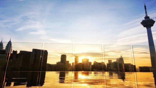 A city skyline with a prominent tower reflecting on water, surrounded by high-rise buildings. - theRED (Kuala Lumpur)