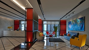 A modern lobby with a reception desk, seating area, and large windows. - theRED (Kuala Lumpur)