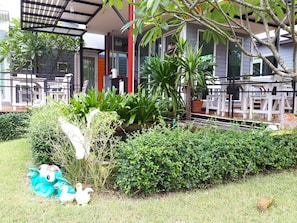 A garden area with various plants, a small pond, and outdoor seating.