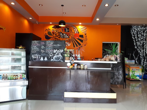 A bar area with a chalkboard menu, a refrigerator stocked with beverages, and a counter with various items.