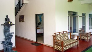 A hotel lobby with a staircase, a sofa, and a statue. - 9 Arch View Rest Inn (Ella)