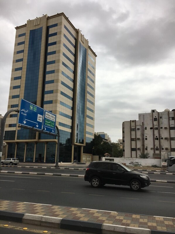 A tall building with a modern design, featuring a glass facade and a blue and beige color scheme. - Diyar Al-Mashaer Hotel  (Makkah)