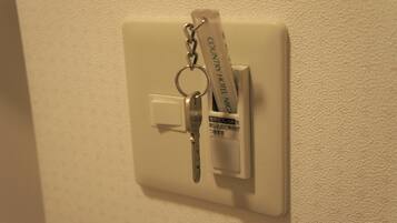 A keychain with a hotel name attached to a wall-mounted switch.