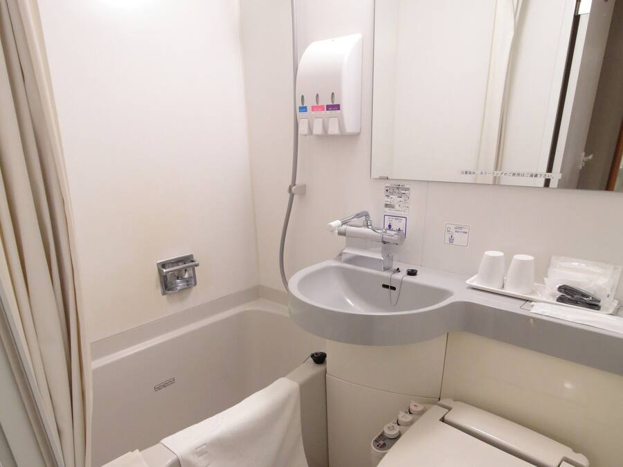 A compact bathroom with a bathtub, a sink, and a toilet.