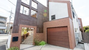 Ein modernes, zweistöckiges Haus mit Garage, großen Fenstern und einer Treppe, die zum Obergeschoss führt.