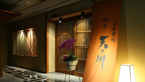 Een traditioneel Japans interieur met tatami vloeren, een shoji-scherm en een potplant.