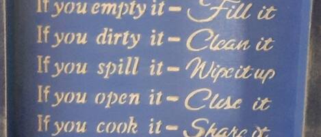 A framed sign with kitchen rules.