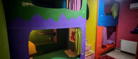 A bunk bed room with a green and purple color scheme, a patterned rug, and a radiator.