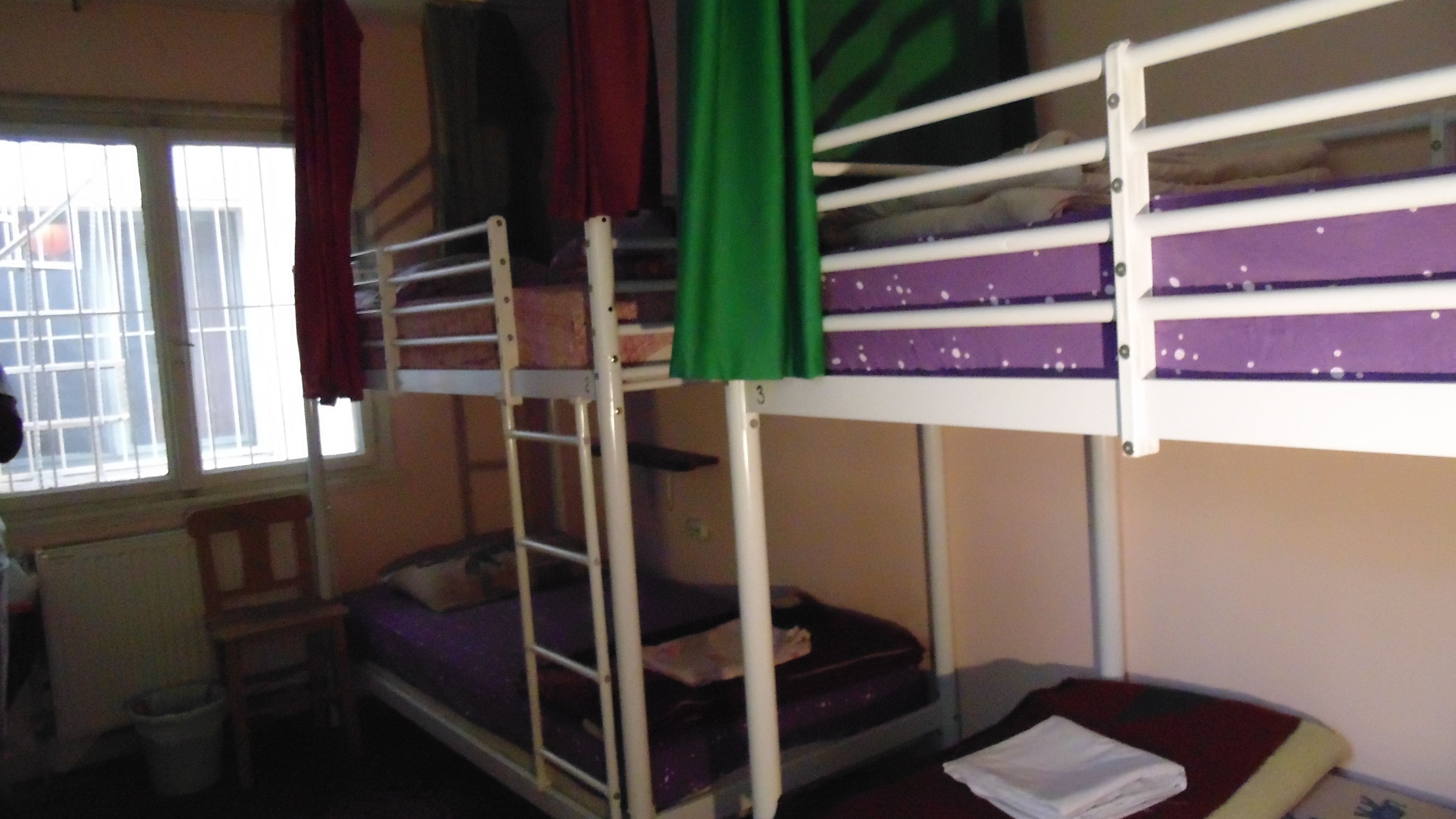 A bunk bed room with a window, a desk, and a chair.