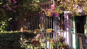 A multi-story building with balconies, some with plants and flowers. There is a sign that reads "OTOPARK" and a gate. - Shantihome Hostel (Izmir)