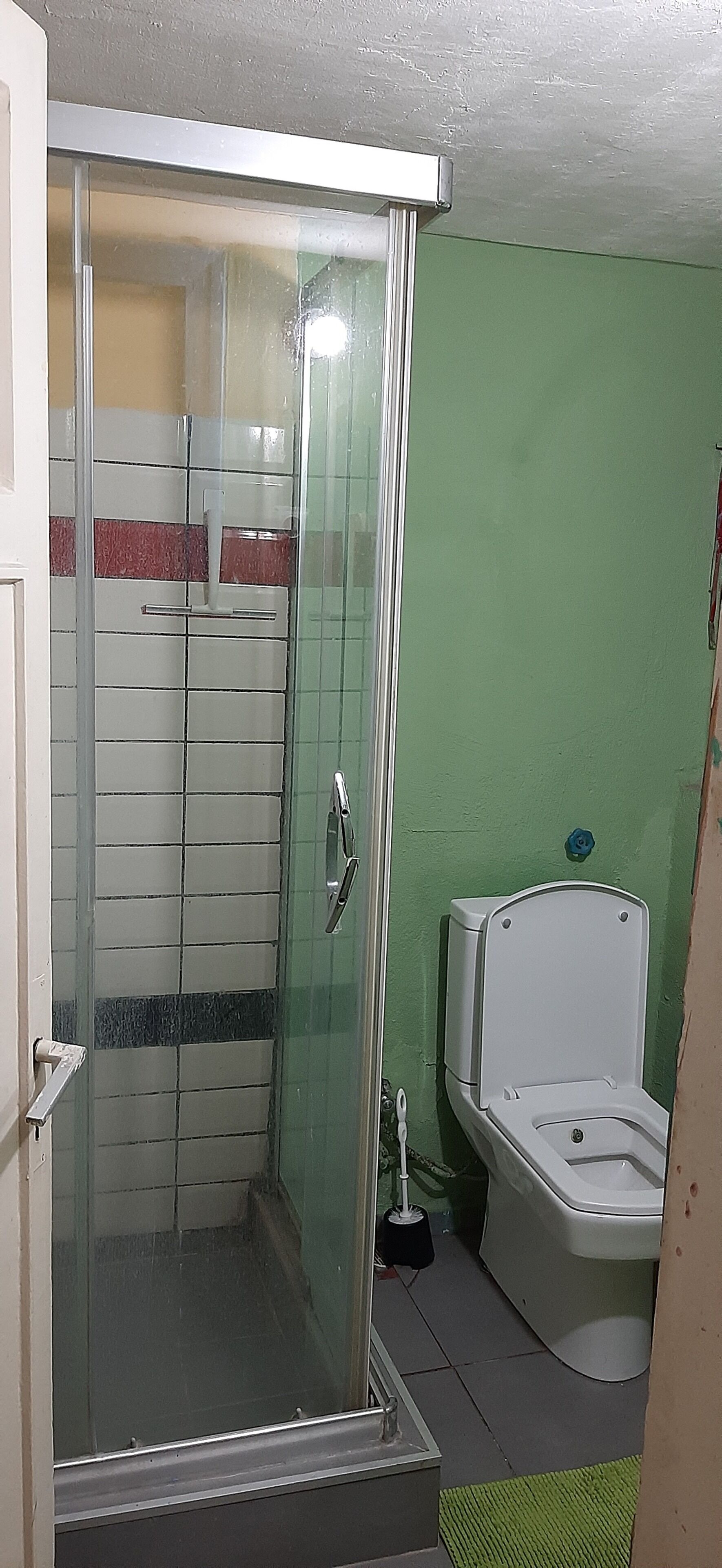 A bathroom with a glass-enclosed shower, a white toilet, and a bathtub.