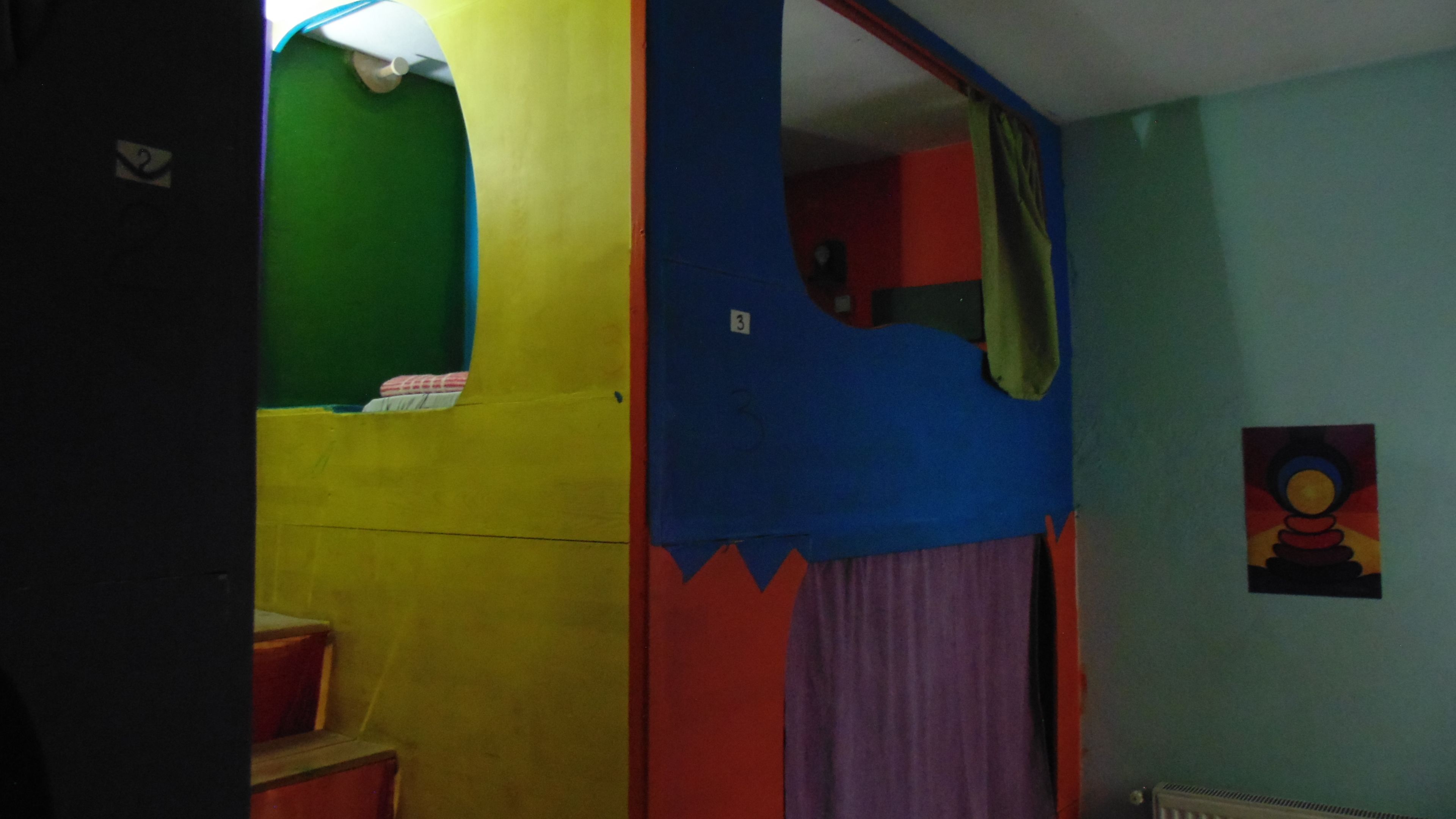 A room with a bunk bed, a small window, and a door.